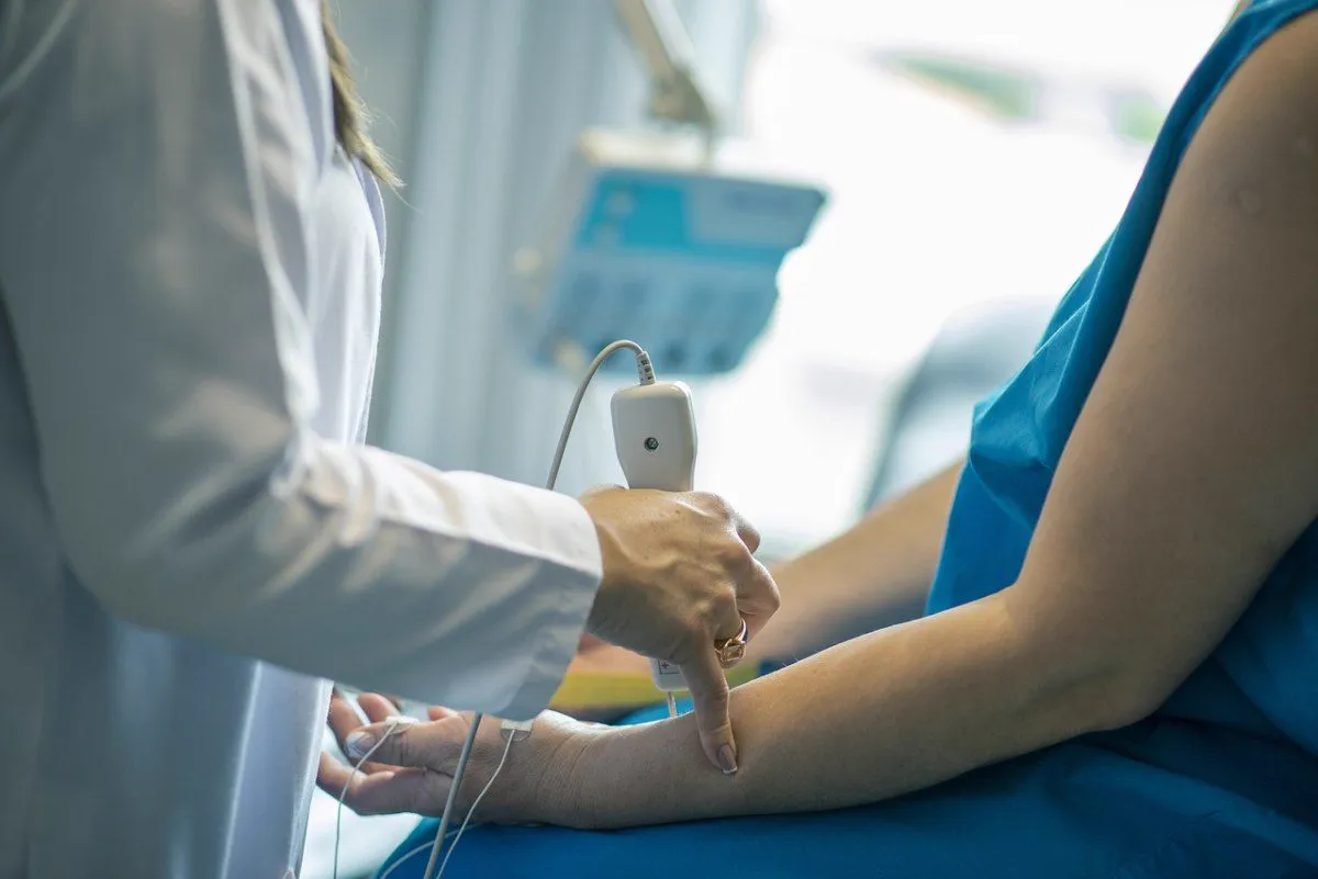 Profissional de saúde examinando o braço de um paciente