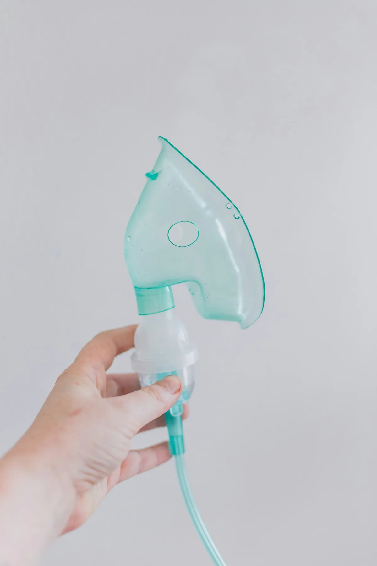 Mão segurando uma máscara de nebulização